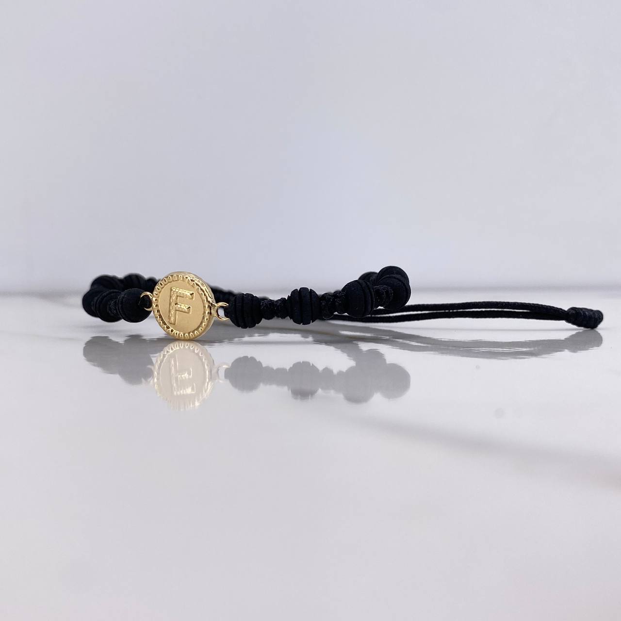 Pulsera Negra Herraje Letra F 0.55gr / 1.5cm / 5mm Troquelado Neoprenos Negros Oro Amarillo $