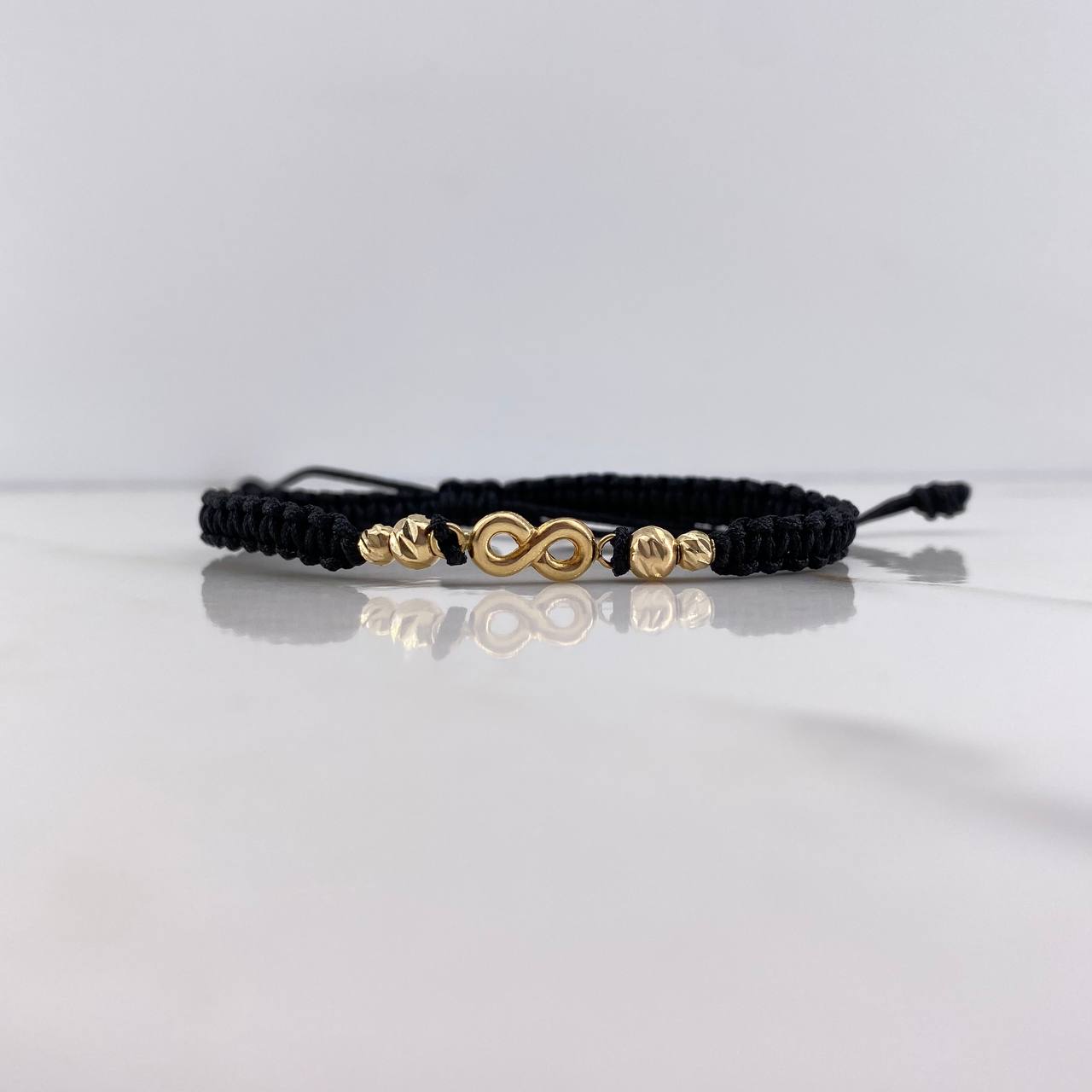 Pulsera Negra Herraje Infinito 0.95gr / 3mm-4mm Bolas Diamantadas Oro Amarillo $