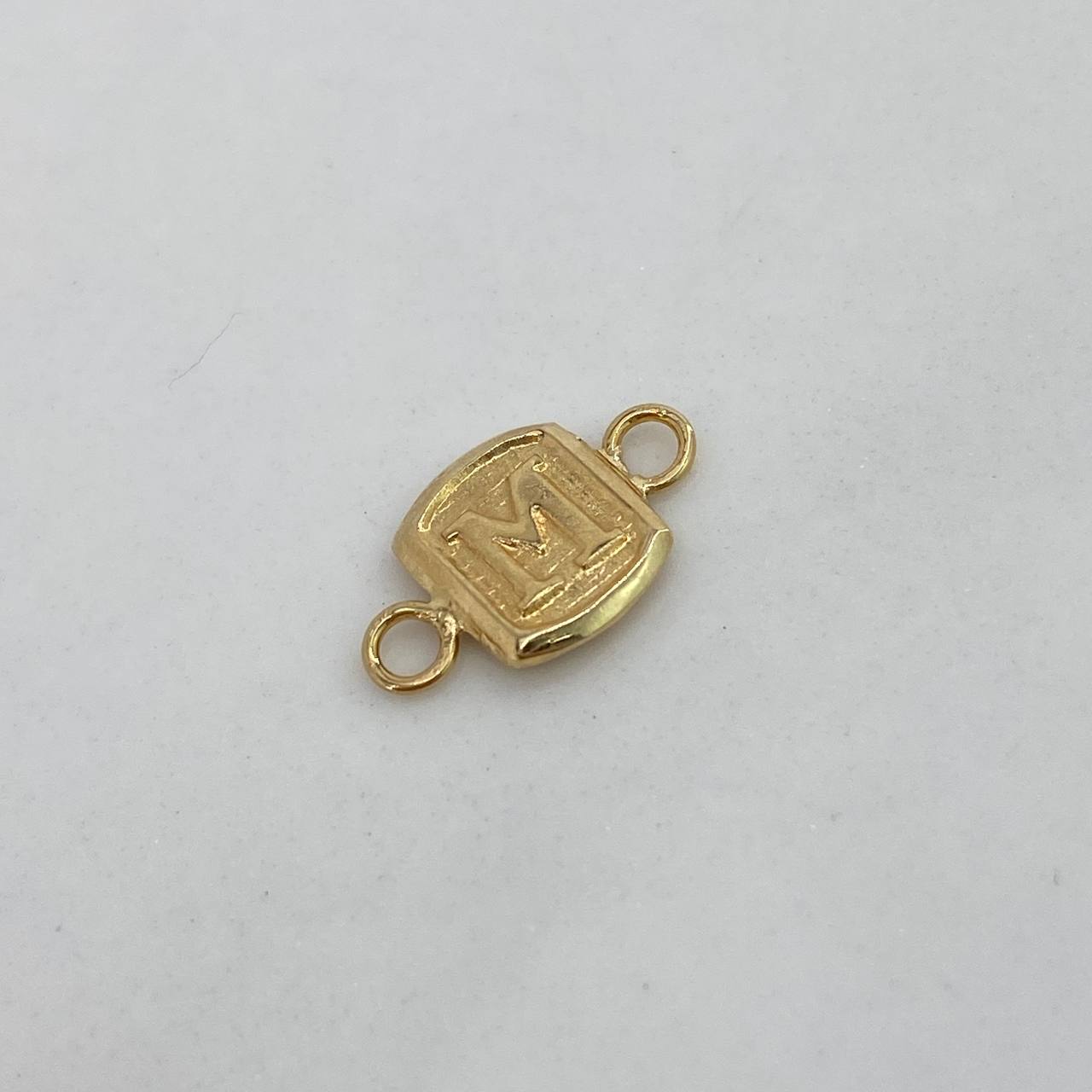 Herraje Marco Letra M  0.4gr / 1.5cm / Liso  Oro Amarillo $